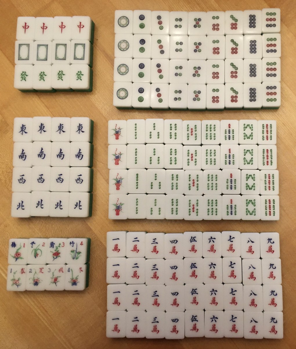Chinese mahjong cards separated by category on a wooden desk
